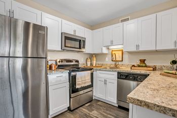 A kitchen with white cabinets and stainless steel appliances